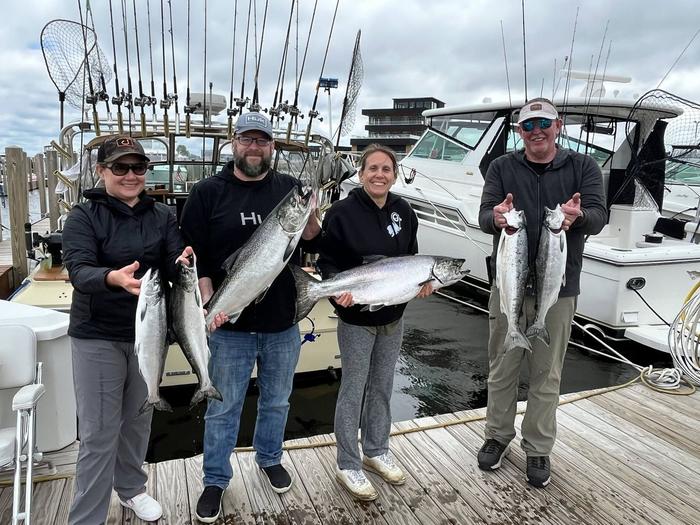 Charter guests with a dockside catch of salmon and steelhead